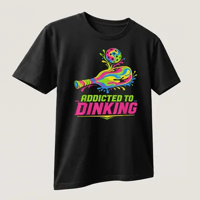 Colorful t-shirt featuring 'Addicted To Dinking' with a pickleball paddle and ball illustration. — printed on a unisex t-shirt (angled view)