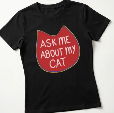 Playful illustration of a cat with the text ask me about my cat in red, white, and yellow — printed on a women's shirt
