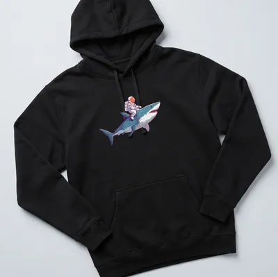 Playful cartoon of an astronaut riding a shark in vibrant colors — printed on a unisex hoodie
