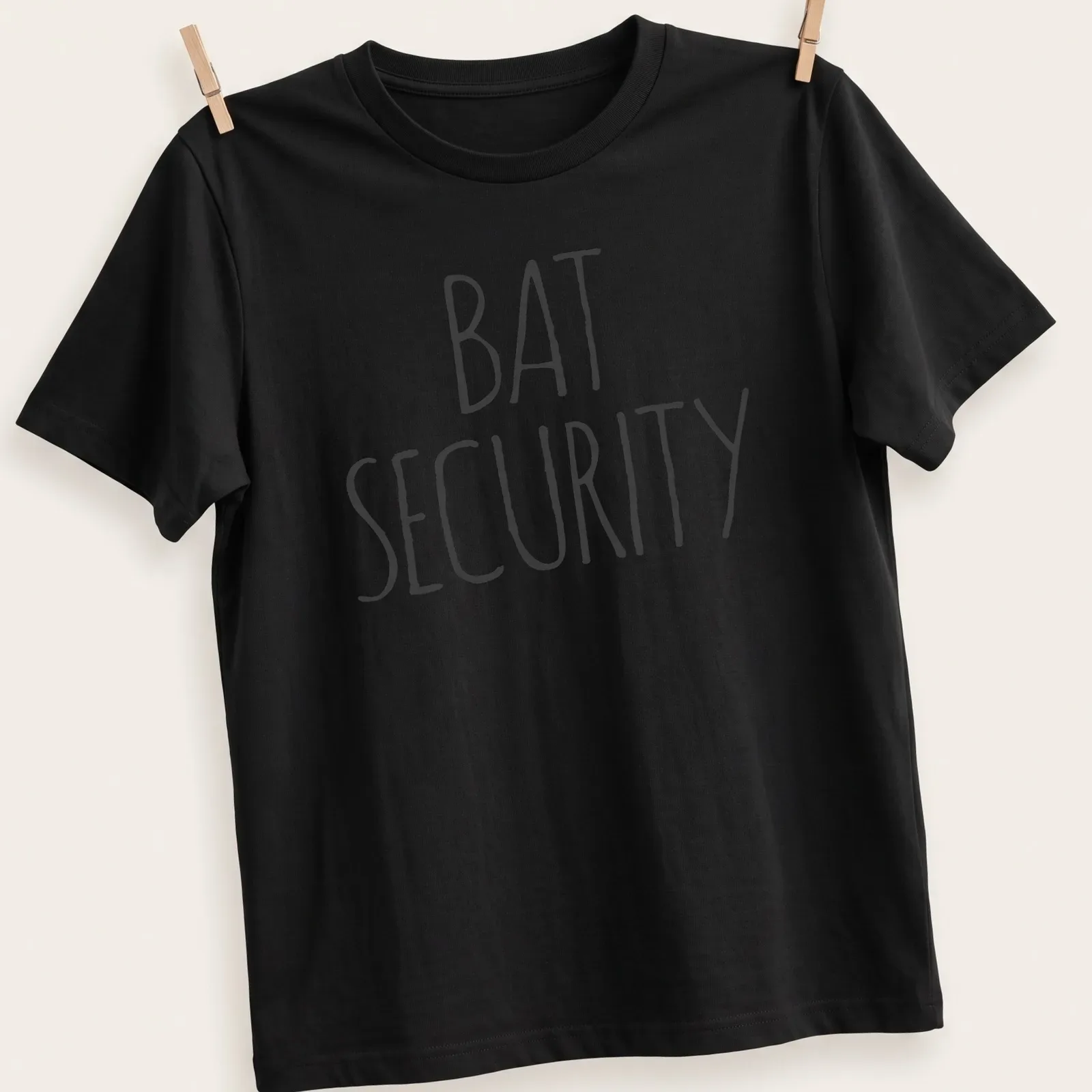 Bold handwritten Bat Security Halloween t-shirt with a bat graphic — printed on a unisex t-shirt