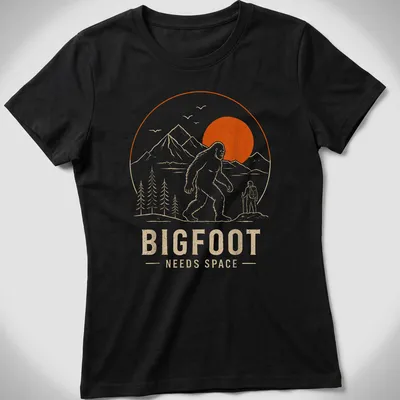 Line art design of Bigfoot with the text Bigfoot Needs Space in orange and beige — printed on a women's shirt