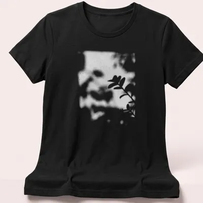Cinematic blurred photo of a plant shadow in black, white, and green — printed on a women's shirt