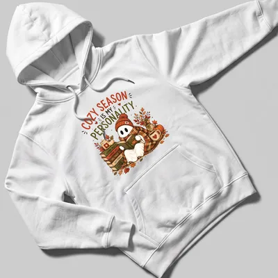 Whimsical illustration of a cute ghost reading with cozy season text — printed on a unisex hoodie