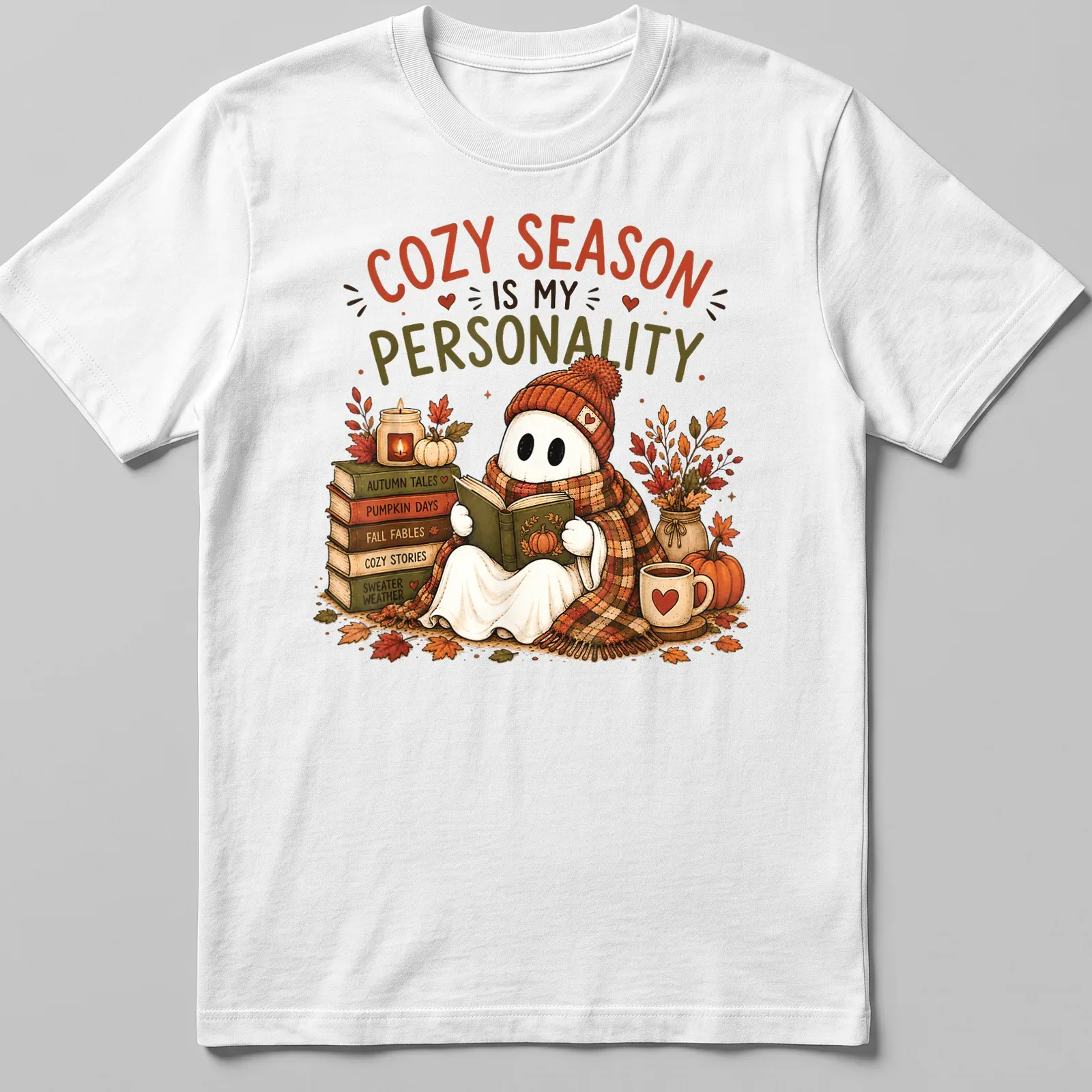 Whimsical illustration of a cute ghost reading with cozy season text — printed on a unisex t-shirt