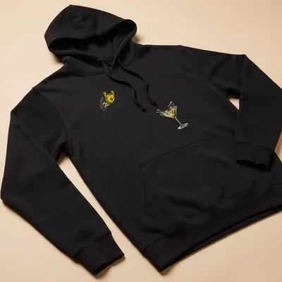 Vintage cartoon olive diving into a cocktail glass in yellow, green, and brown — printed on a unisex hoodie