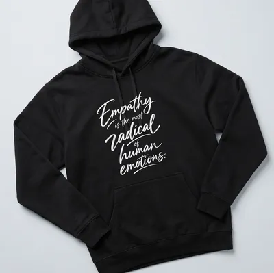 White typography on a shirt stating 'Empathy is the most radical of human emotions.' — printed on a unisex hoodie