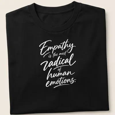 White typography on a shirt stating 'Empathy is the most radical of human emotions.'