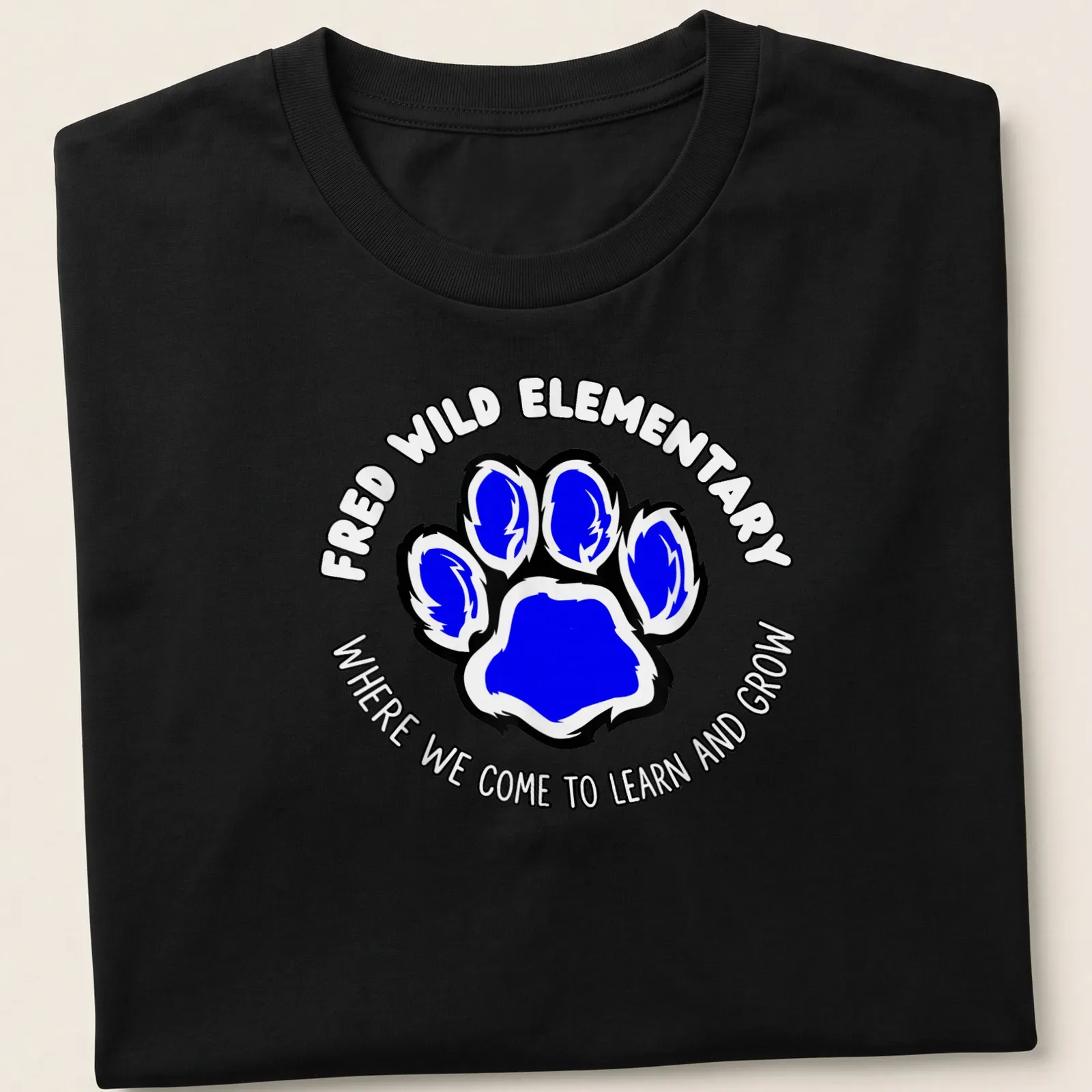 Bold design with blue paw print and text about learning and growing — printed on a unisex t-shirt