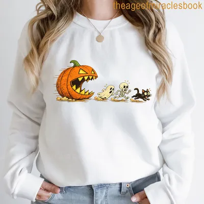 Cartoon Halloween T-shirt with a black cat chasing a pumpkin, ghost, and skeleton — printed on a sweatshirt