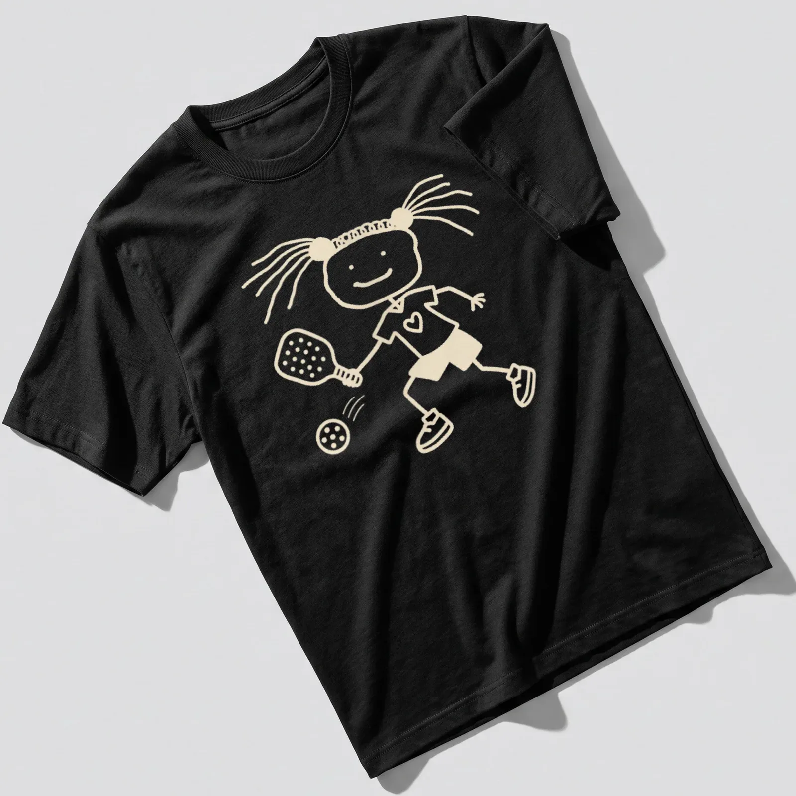 Stick figure girl playing pickleball in simple line-art with beige and white colors. — printed on a unisex t-shirt
