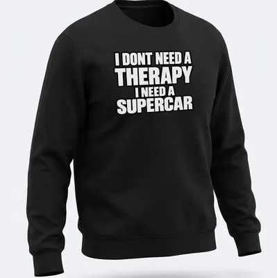 Bold typography t-shirt with the text I DONT NEED A THERAPY I NEED A SUPERCAR on a black background — printed on a unisex sweatshirt