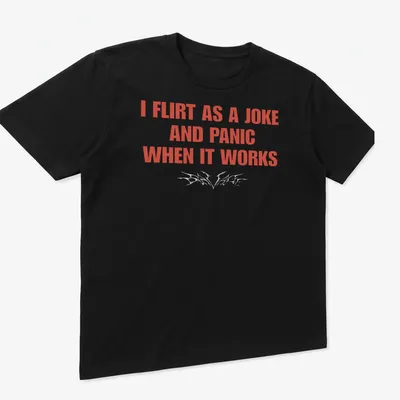 Bold typography shirt reading I Flirt As A Joke And Panic When It Works — printed on a unisex t-shirt (angled view)