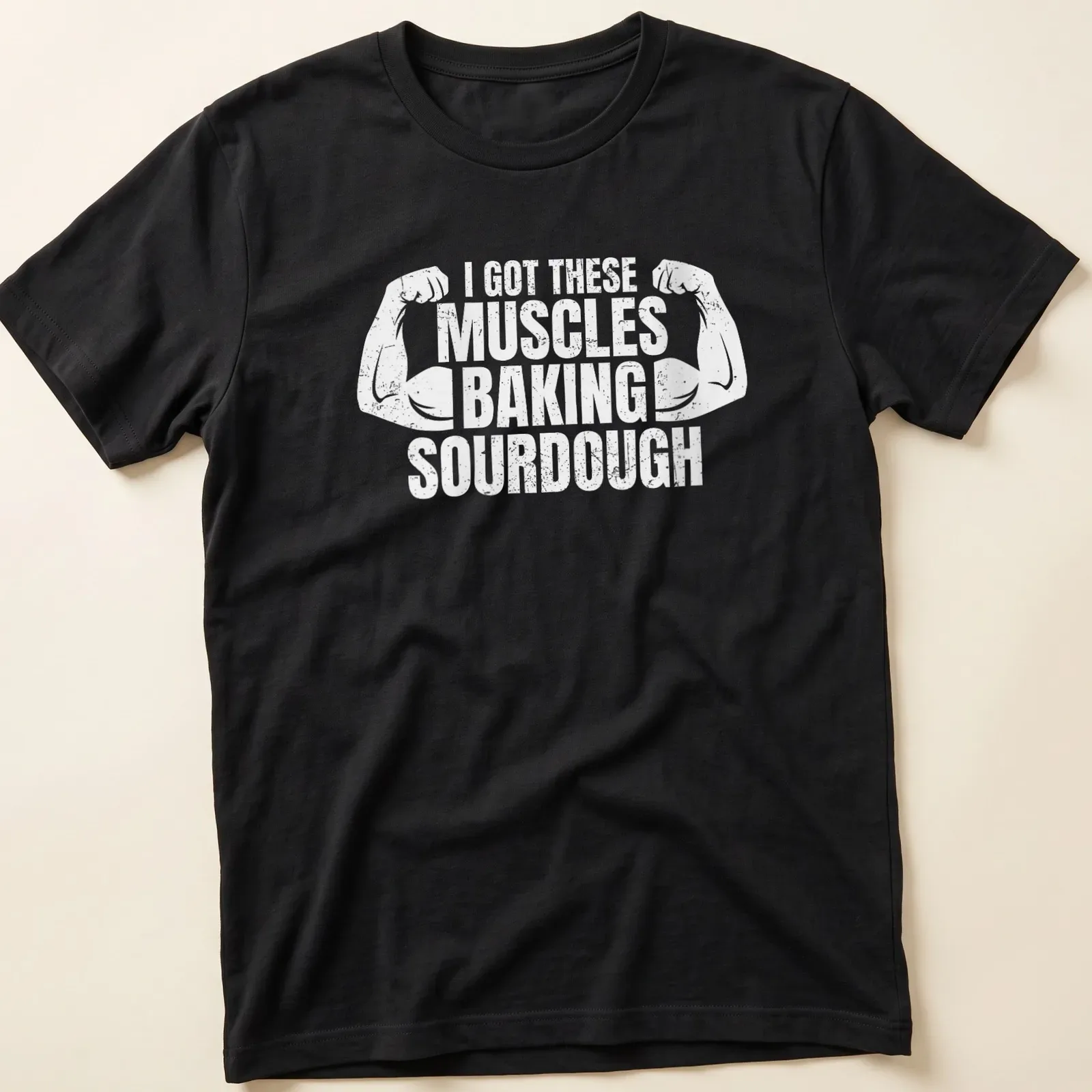 Distressed T-shirt with flexing arms and humorous baking text — printed on a unisex t-shirt