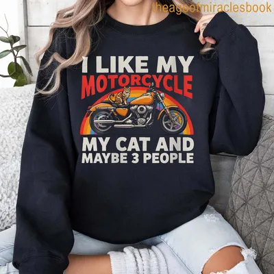 Colorful retro design T-shirt featuring a motorcycle and a cat with playful text — printed on a sweatshirt