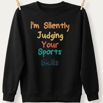 Colorful typography shirt with playful text about judging sports skills — printed on a unisex sweatshirt