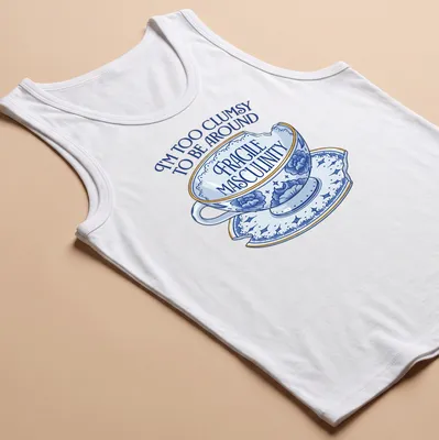 Whimsical illustration of a broken teacup with humorous text about masculinity — printed on a tank top