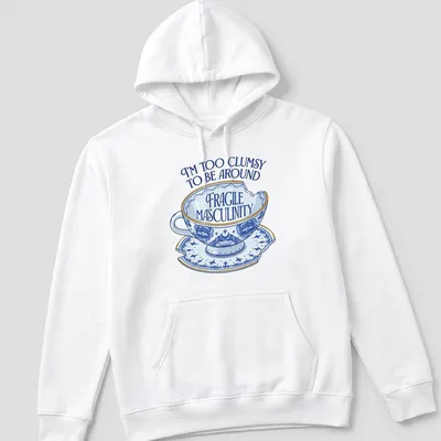 Whimsical illustration of a broken teacup with humorous text about masculinity — printed on a unisex hoodie
