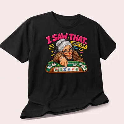 Colorful cartoon of a Mahjong player with text 'I SAW THAT. NICE TRY.' — printed on a unisex t-shirt (angled view)