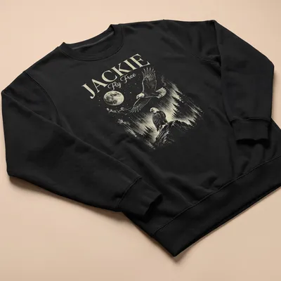Vintage illustration of an eagle flying with the moon in the background, printed in gold and green. — printed on a unisex sweatshirt