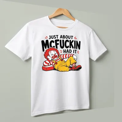 Cartoon clown graphic with the text 'Just About McFuckin Had It' in bold colors — printed on a unisex t-shirt (angled view)