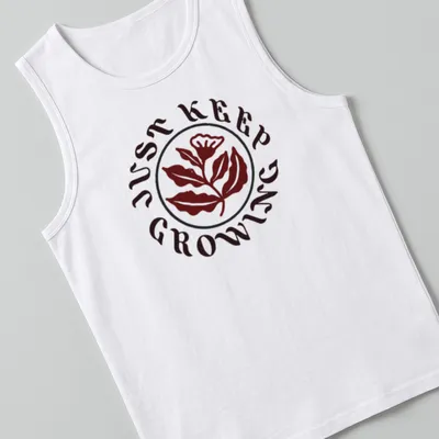 Floral design with leaves and text 'JUST KEEP GROWING' in dark red, green, and white — printed on a tank top
