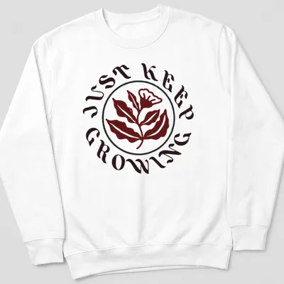 Floral design with leaves and text 'JUST KEEP GROWING' in dark red, green, and white — printed on a unisex sweatshirt