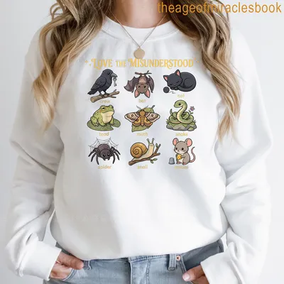 Kawaii cartoon t-shirt featuring a cat, bat, frog, and spider with colorful text. — printed on a sweatshirt