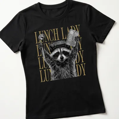 Black and white graphic of a raccoon with bold gold text saying Lunch Lady — printed on a women's shirt