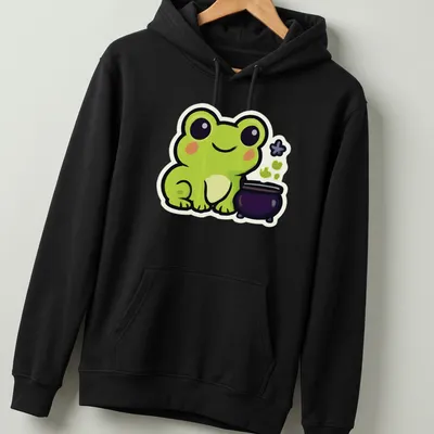 Kawaii frog next to a bubbling cauldron in green, black, purple, and white — printed on a unisex hoodie