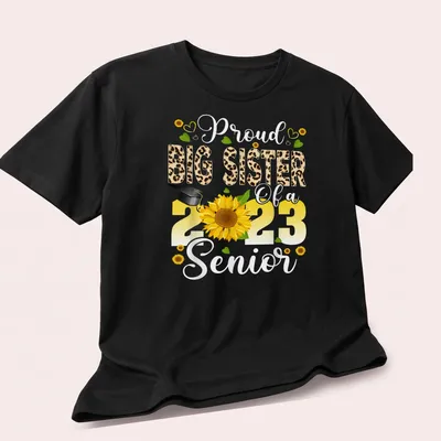 Colorful design featuring a proud big sister message with sunflower and graduation cap — printed on a unisex t-shirt (angled view)