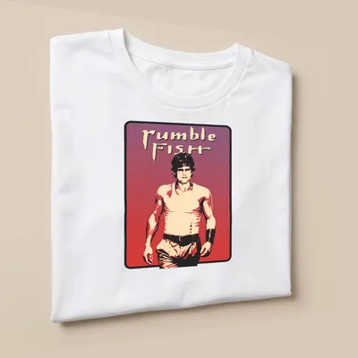 Vintage aesthetic t-shirt featuring Rumble Fish character and text in bold font — printed on a unisex t-shirt (angled view)