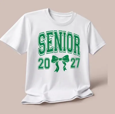 Green Senior 20 27 t-shirt featuring a Coquette bow and collegiate style — printed on a unisex t-shirt (angled view)