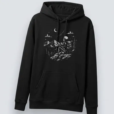 Vintage illustration of a skeleton hiker enjoying a mountain view in shades of gray and green. — printed on a unisex hoodie