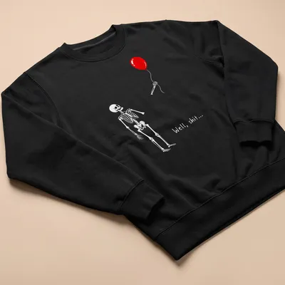Humorous cartoon skeleton struggling with a red balloon and text saying 'Well, shit...' — printed on a unisex sweatshirt