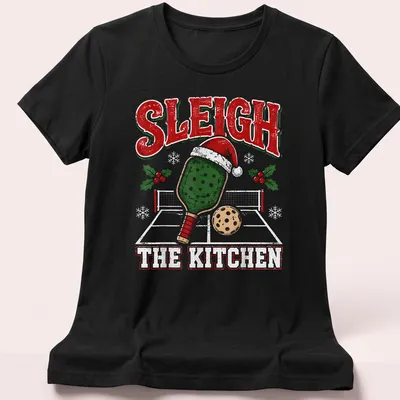 Vintage distressed Christmas shirt with 'Sleigh The Kitchen' and a pickleball paddle wearing a Santa hat — printed on a women's shirt