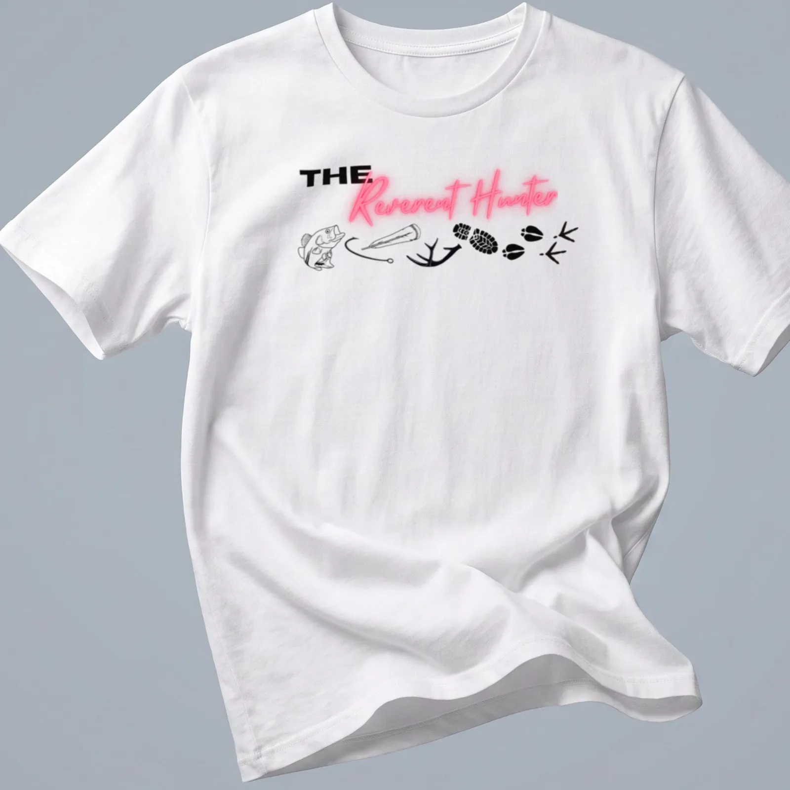 Bold typography tee featuring 'THE Reverent Hunter' with fishing and wildlife elements — printed on a unisex t-shirt