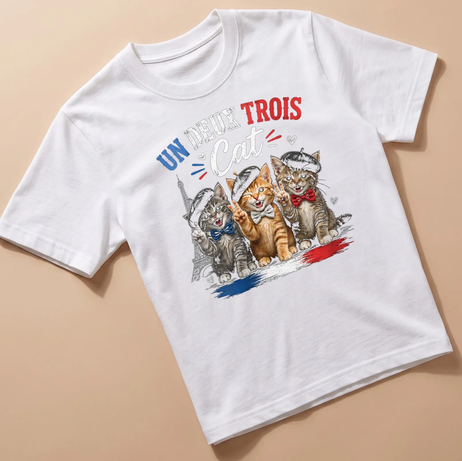 Colorful cartoon print of three cats in berets with the text Un Deux Trois Cat — printed on a unisex t-shirt