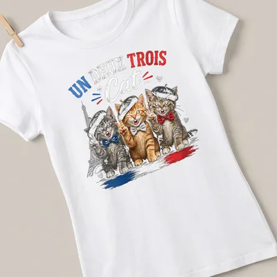 Colorful cartoon print of three cats in berets with the text Un Deux Trois Cat — printed on a women's shirt