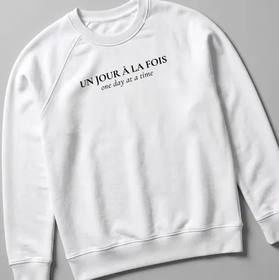 Typographic design with French and English text: Un Jour À La FOIS one day at a time — printed on a unisex sweatshirt