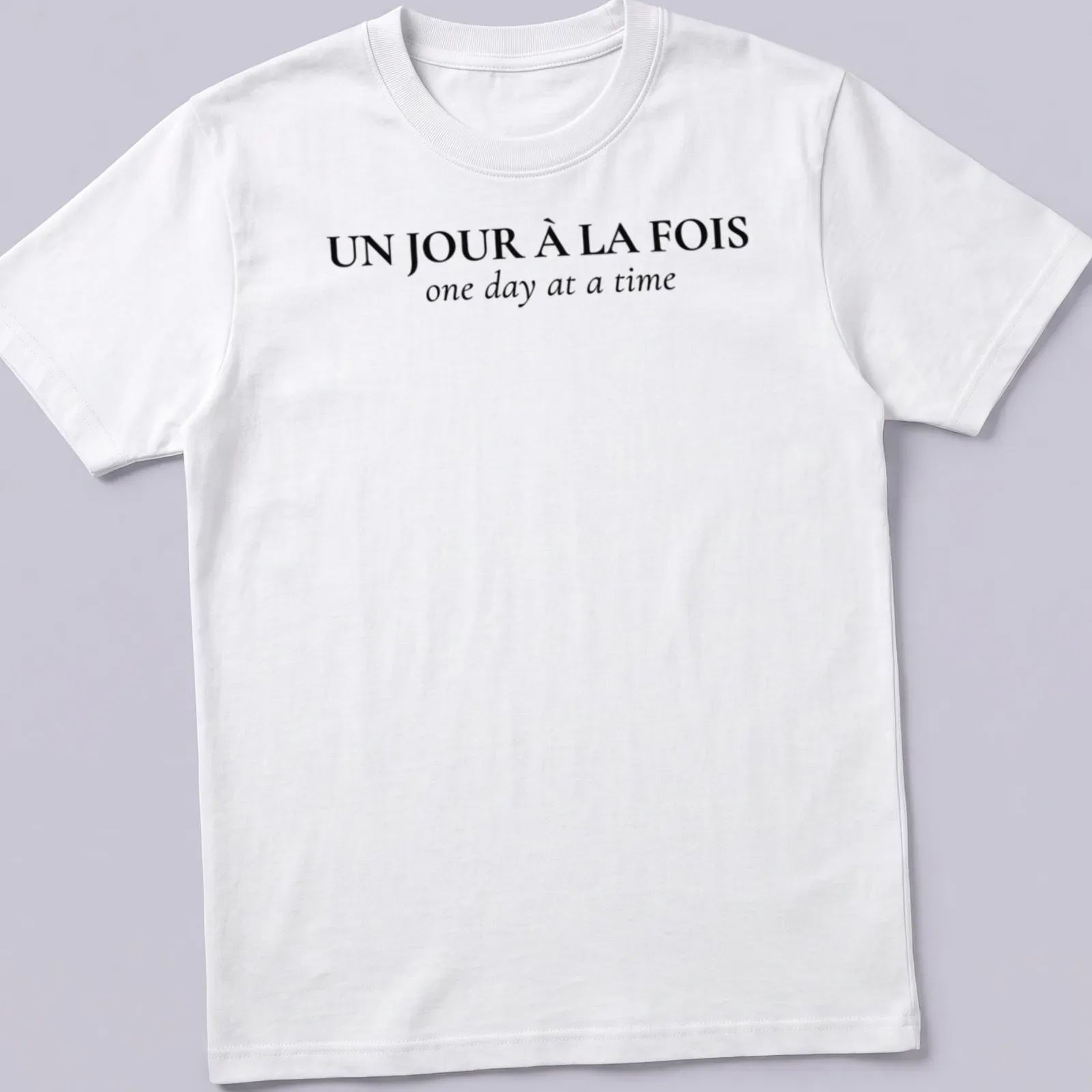 Typographic design with French and English text: Un Jour À La FOIS one day at a time — printed on a unisex t-shirt