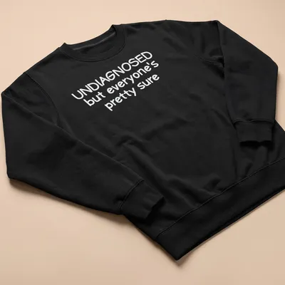 Funny t-shirt with text 'UNDIAGNOSED but everyone's pretty sure' — printed on a unisex sweatshirt